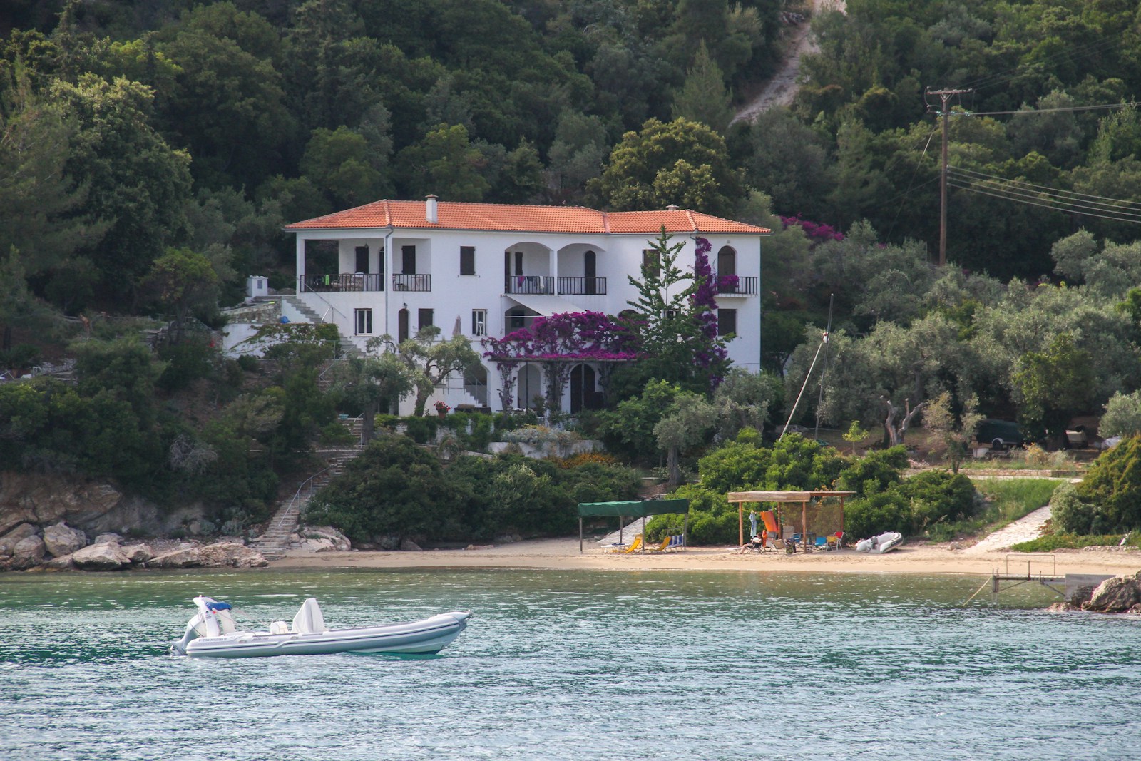 a boat is in the water in front of a house, home